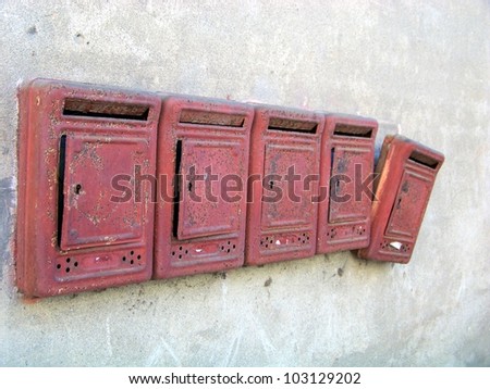 old red mail boxes on a grey wall