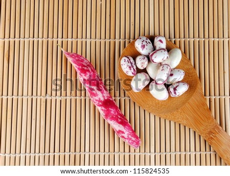 purple beans over a spoon on a bamboo place mat
