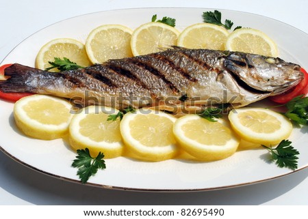 grill cooked fish with lemon slices and parsley