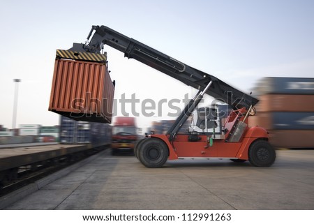Crane lifting up container in railroad yard