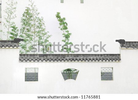 Wall with windows and bamboo.this wall with roof is familiar in chinese ancient building.