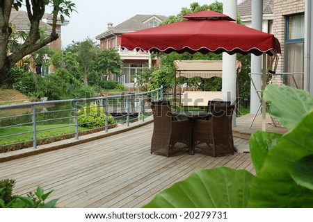 House backyard with table and chairs by a small river.