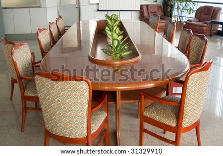 Board room with a big polished table and arm-chairs