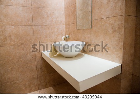 Decorated and tiled bathroom with  white porcelain sink in a new bathroom