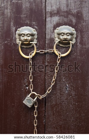 Old Chinese style  door with iron chain and  mythical wild animal head door handles.