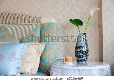 Modern style interior with with bed, pillows, bedside table,teacup and vase