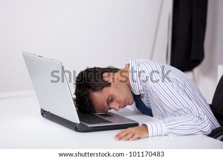 Businessman sleeping at his office over his laptop