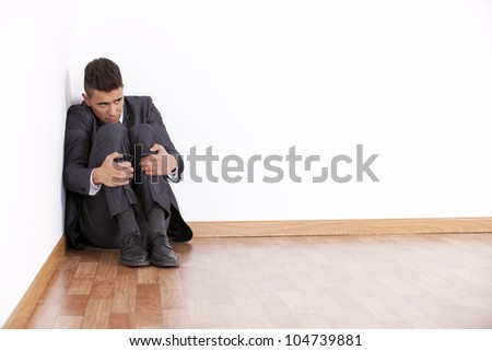 Businessman at the corner of his office room with fear