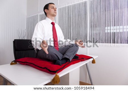 Businessman at the office in lotus yoga position