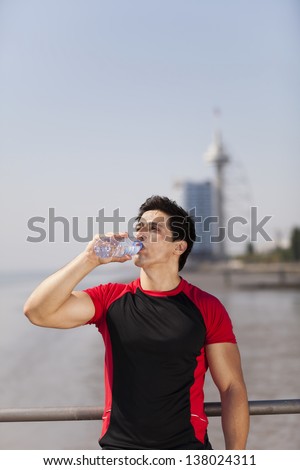 Tired athlete refreshing him self with fresh water