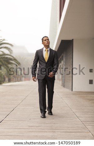 Confident businessman walking next to his office building