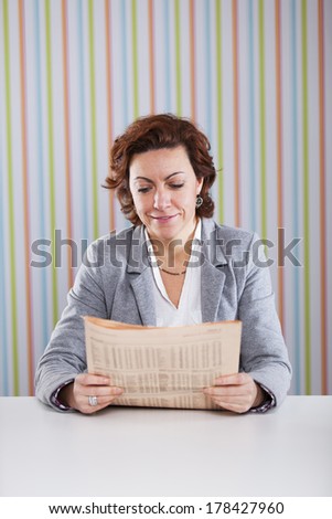 Businesswoman reading the newspaper at the office