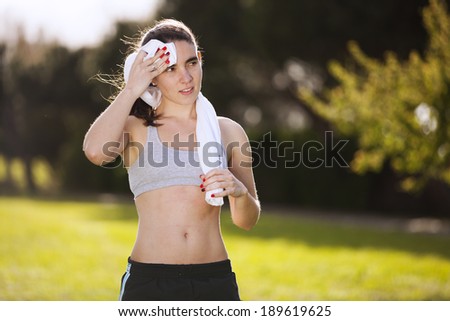 Woman refreshing after running at the city park