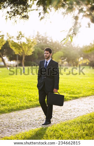 Businessman walking at the city garden