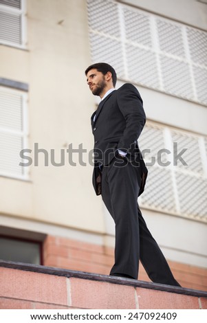 Powerful businessman walking at the roof