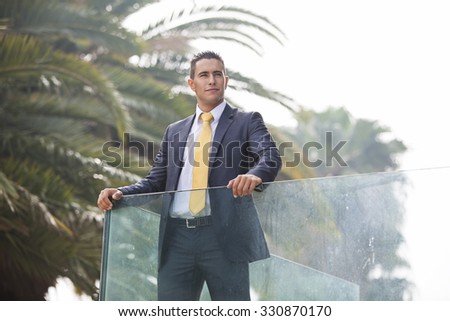 Confident young businessman at his office balcony