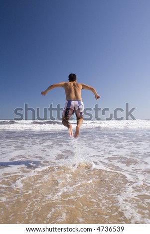 a men jumping in a paradise beach (moving blur)