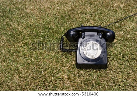 an old telephone on a green grass