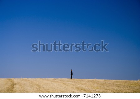 a businessman alone on the top of the field
