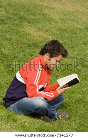 young man sit in the park enjoying the fresh air and reading a book