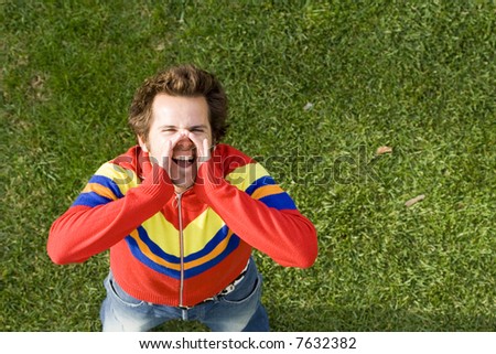 A high view perspective of a young man screaming ans shouting out loud