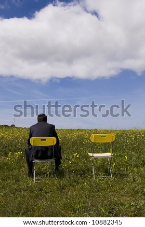 Businessman back sitting in a yellow chair waiting for his partner