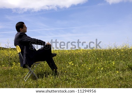 Businessman sitting in a yellow chair enjoying the nature
