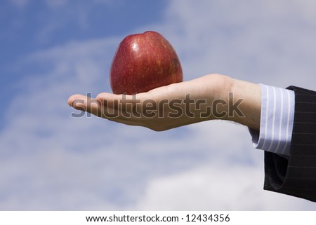 a businessman hand holding an apple, as symbol of business temptation