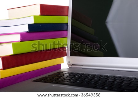 Colorful books next to a modern laptop