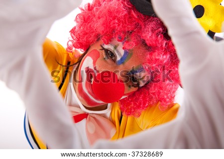 funny clown peeking between his fingers (hand framing)