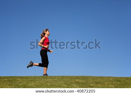 woman running in the green grass (with copy space)
