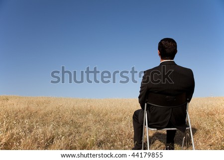 businessman sited in a chair looking to the landscape