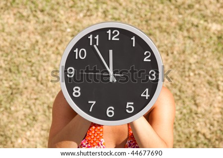 hands holding a clock in front of the face