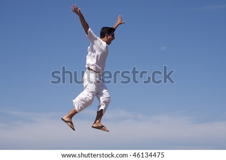 young men jumping and raising his arms up to the air