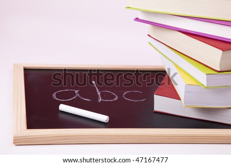 ABC letters written on a blackboard with colorful books (selective focus)