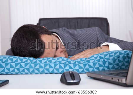Exhausted businessman sleeping at his office