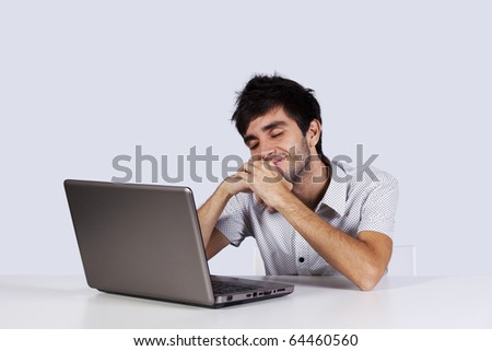 Young man with happy dreams in front of his laptop