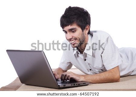 young man surfing the internet in his laptop sited on the carpet (isolated on white)