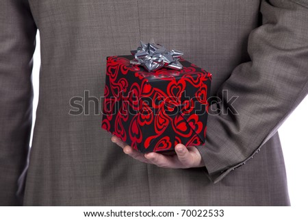 Businessman holding a wrapped Valentine present behind his back