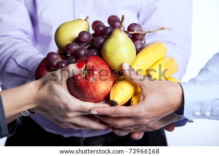 Group of people hands holding apples, oranges, pears, grapes and bananas (selective focus)