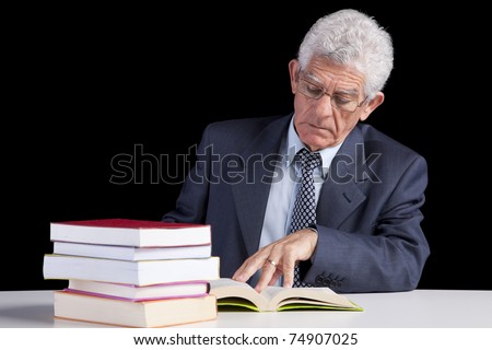 Senior teacher reading some books (isolated on black)