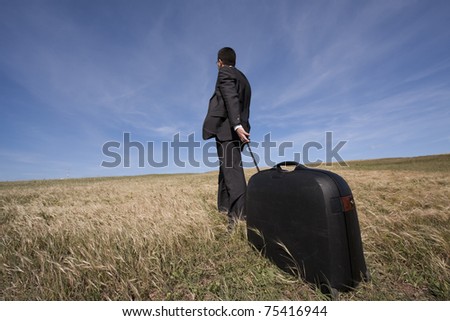 businessman with his luggage outdoor in the field