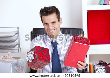 Happy businessman at his office giving christmas gifts