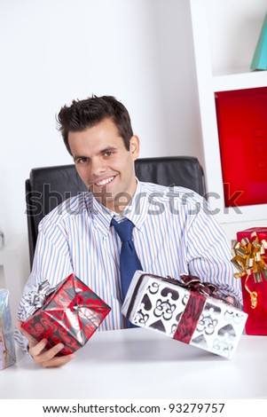Happy businessman at his office giving valentine day gifts