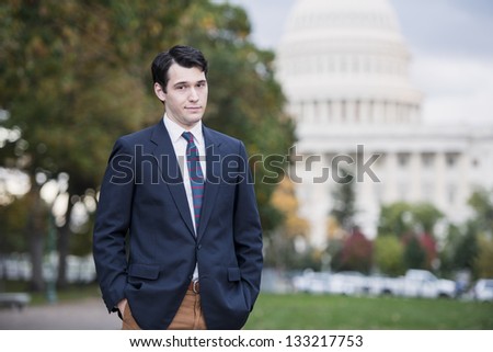 Businessman Standing In Front Of US Capitol With A Sour Look On His Face