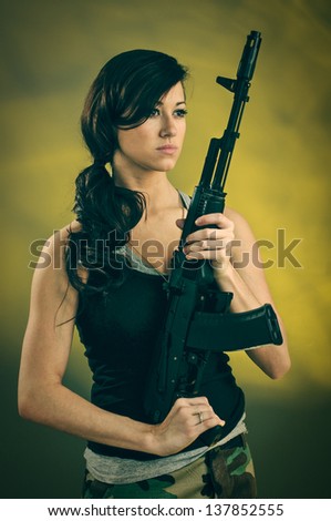 A young caucasian woman with an assault rifle.