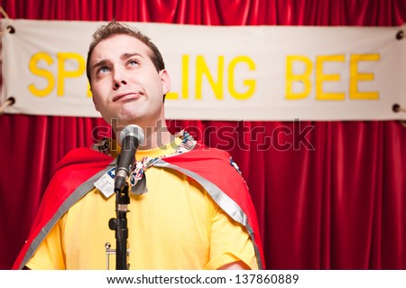 A grown man pretending to be a young boy competing in a spelling bee.