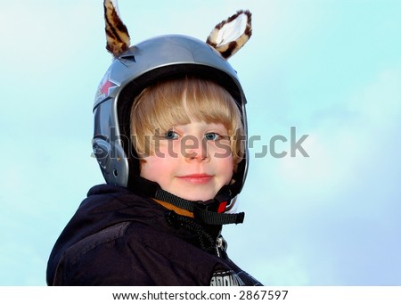 Smiling boy in a protective ski helmet with funny tiger ears
