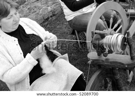 RATIBORICE, CZECH REPUBLIC - APRIL 24: Older woman spinning wool on traditional spinning wheel - black and white image, The Shepherds Festival 2010, on April 24, 2010 in Ratiborice, Czech Republic