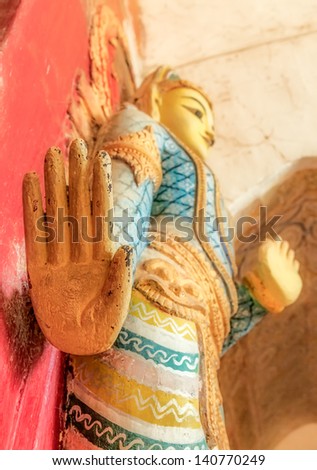 BAGAN, MYANMAR - FEBRUARY 23: Old wooden Door Guardian statue hand detail in front of the east entrance of the Ananda temple  on February 23, 2013 in Bagan, Myanmar.